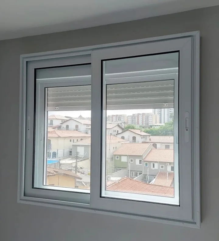 Janela acústica de sobrepor com perfil branco e persiana, instalada pela Audium